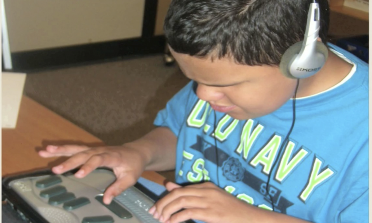 A boy uses a braille notetaker.