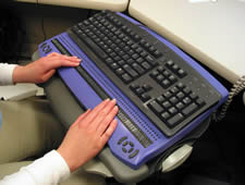 Photo of person sitting at keyboard with refreshable braille display.