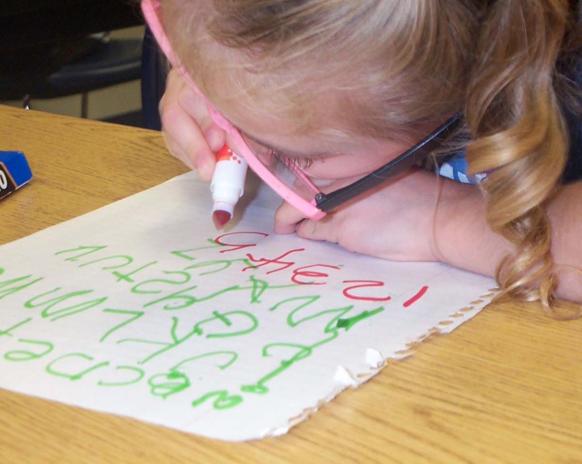 Haylee wrting her numbers and letters - working about 2 inchs from the paper.