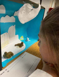 Third grade student up close looking at an arctic diorama.