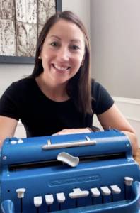 Stacey Chambers sitting in front of a braille writer.