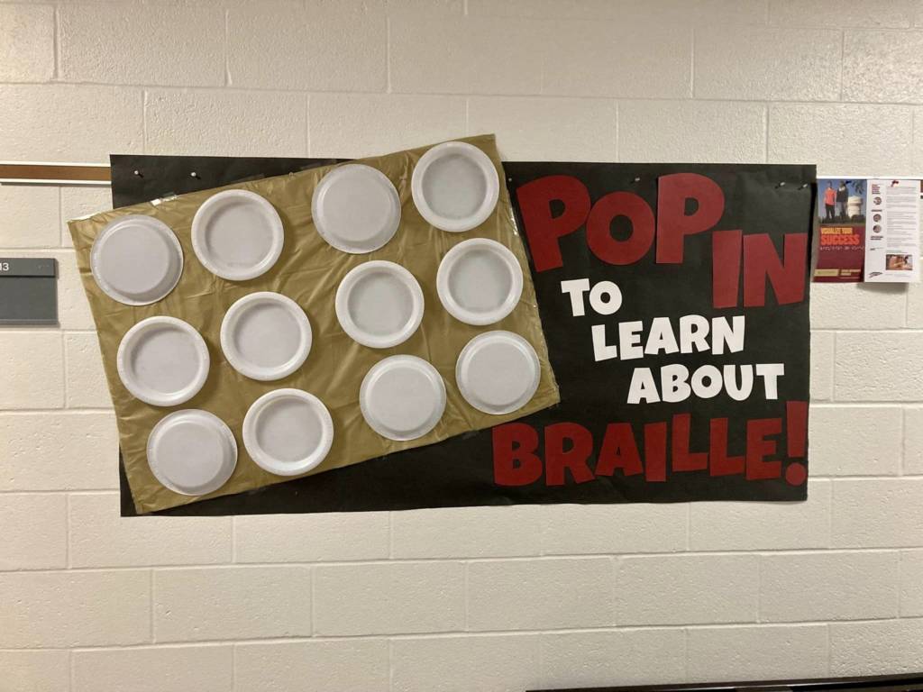Completed sign that says, "Pop in to Learn about Braille!" with the plates representing braille.