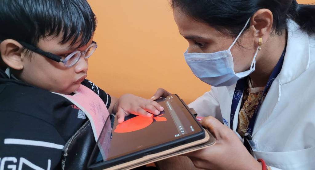 Child touching a red apple on the iPad