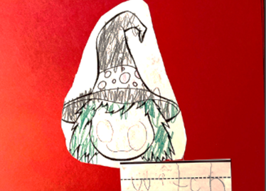 Picture of a witch colored by the student and the facial features are drawn and the student wrote the word witch.