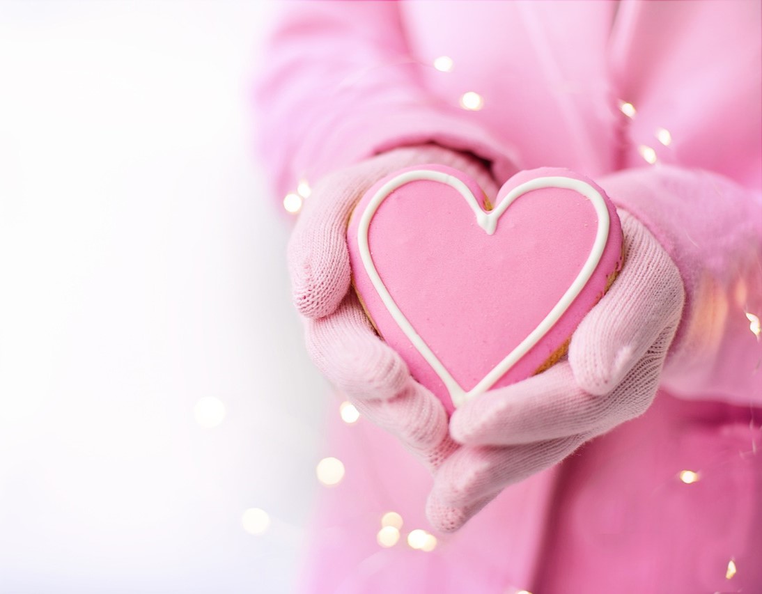 Cookie in the shape of a heart being held in hands