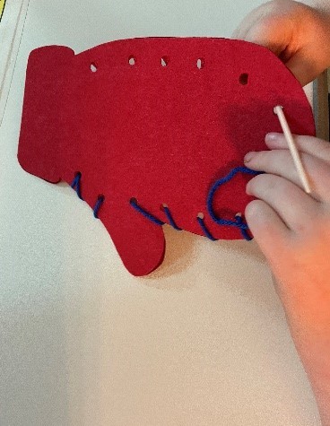 Student sewing the mitten.