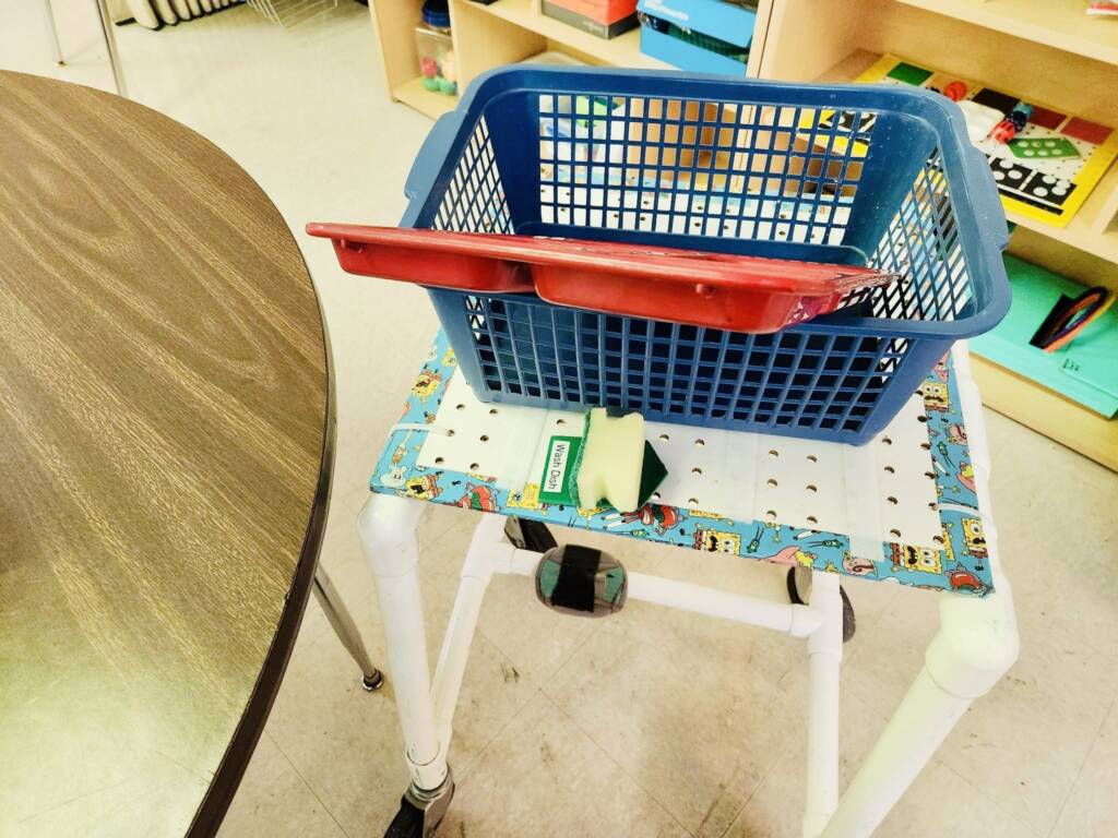 Modified push cart with a basket and supplies on top. 
