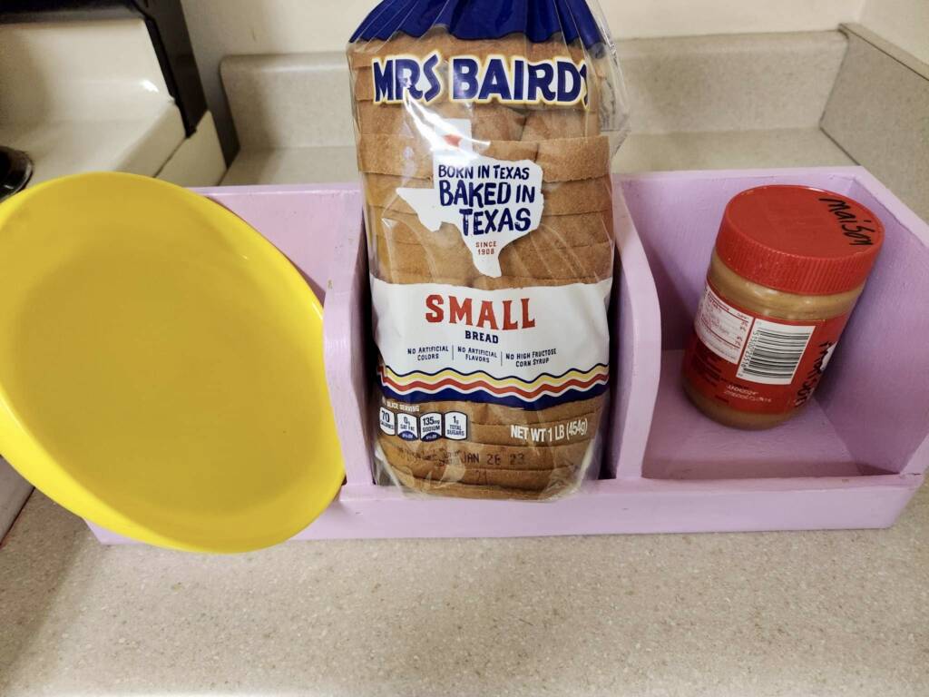 A plate, loaf of bread, and jar of peanut butter in a 3-slot sequence box