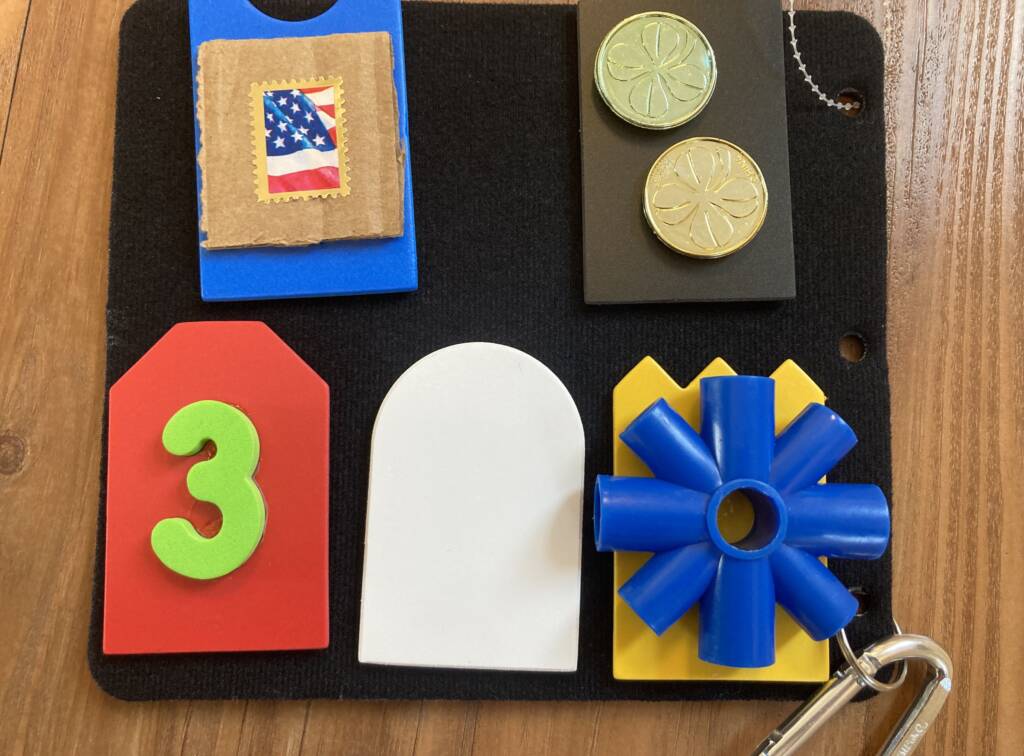 3-D symbols that include a the laundry room is a hook, the school store is a couple of gold coins, and the student’s classroom is a number 3, the first number in his classroom number.