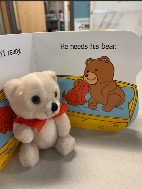 Clifford's Bedtime book on the page that reads, "He needs his bear." and a small teddy bear in front of the book.