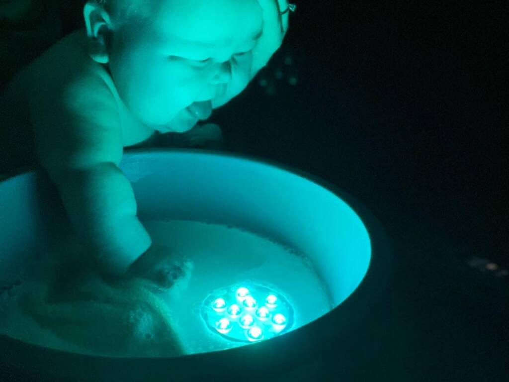 Young child looking at a light up circle shaped toy