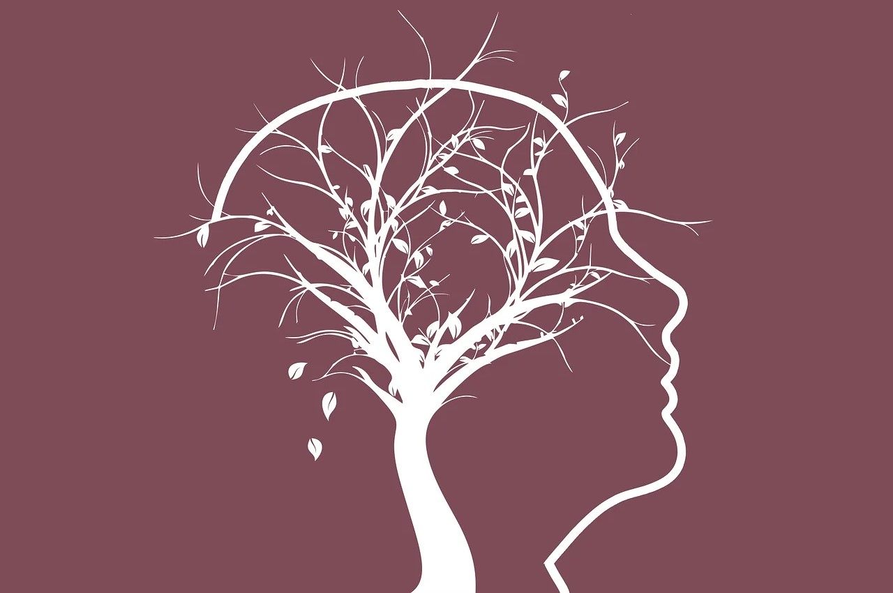Illustration for side profile of a face with a tree in the brain part as neuropathways.