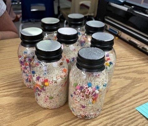 Several plastic bottles filled with rice and various colored beads.