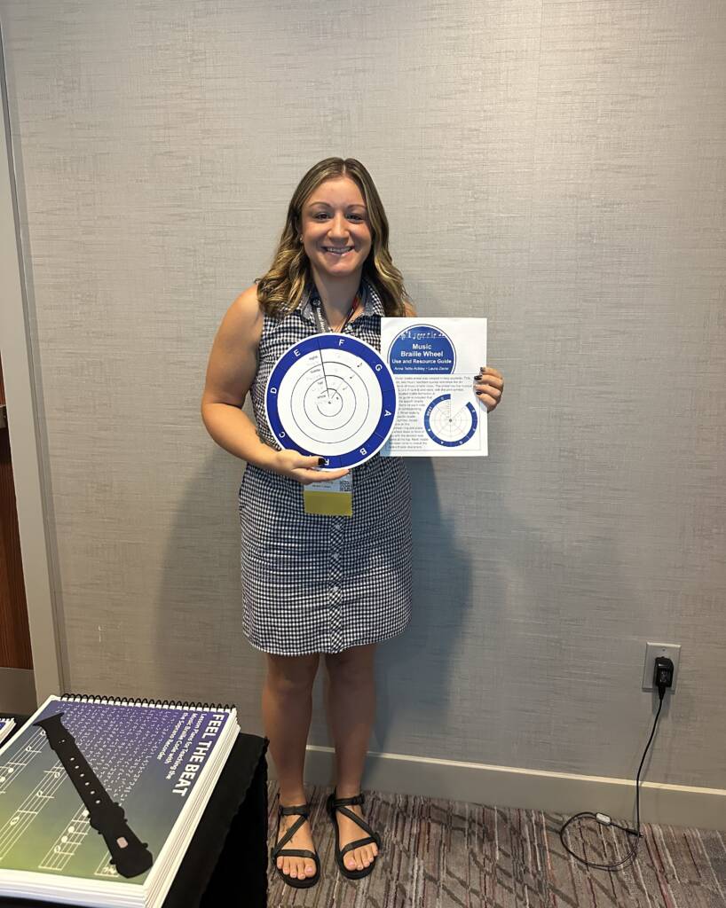 Anna holding the braille music wheel at the APH conference.