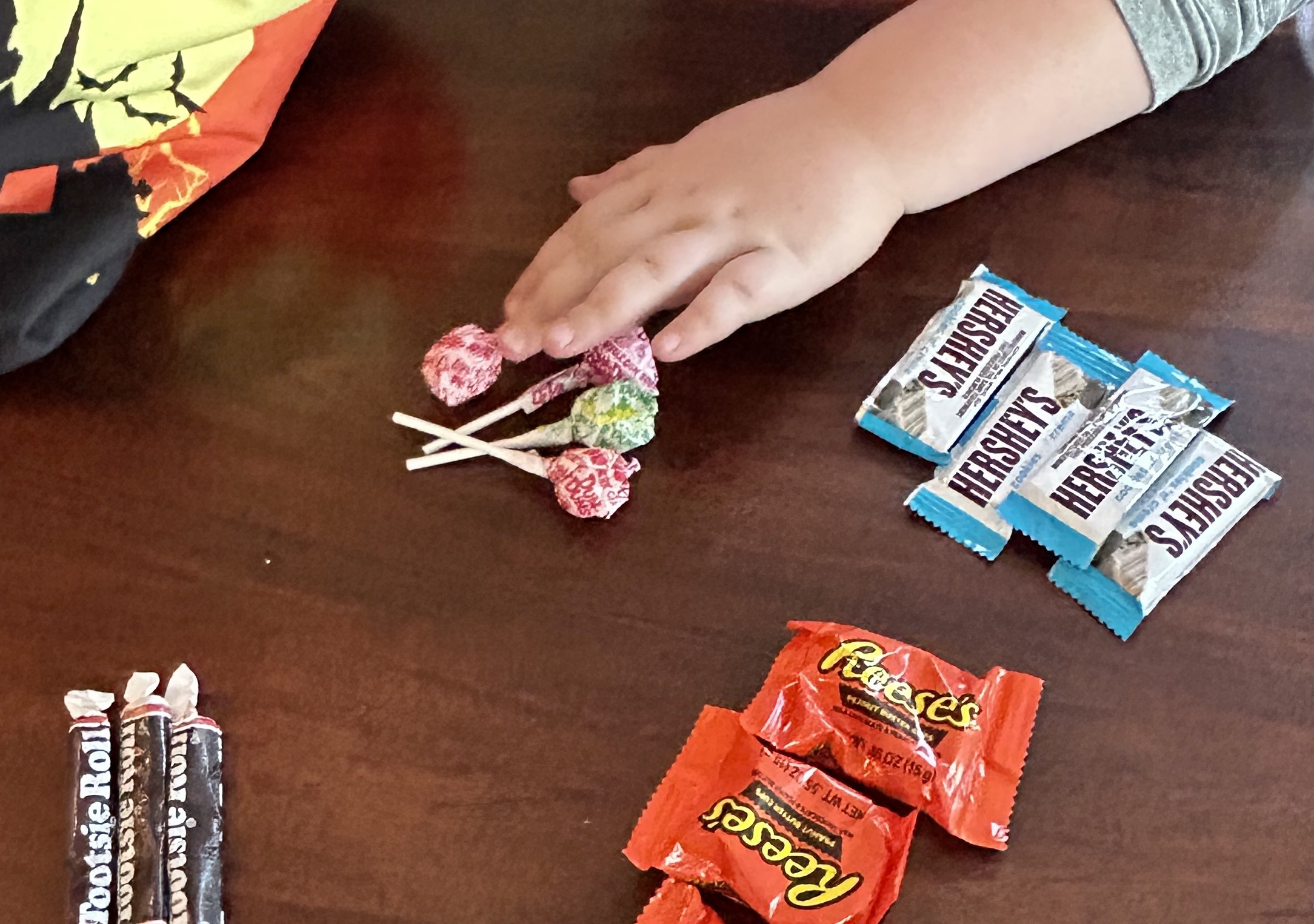 Child's hand sorting candy from Halloween