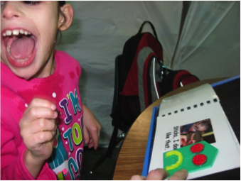 The same student, laughing with excitement, at being able to interpret the 3-D symbol in her book for “sad”