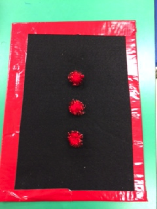 Red pompoms on black background with red outline