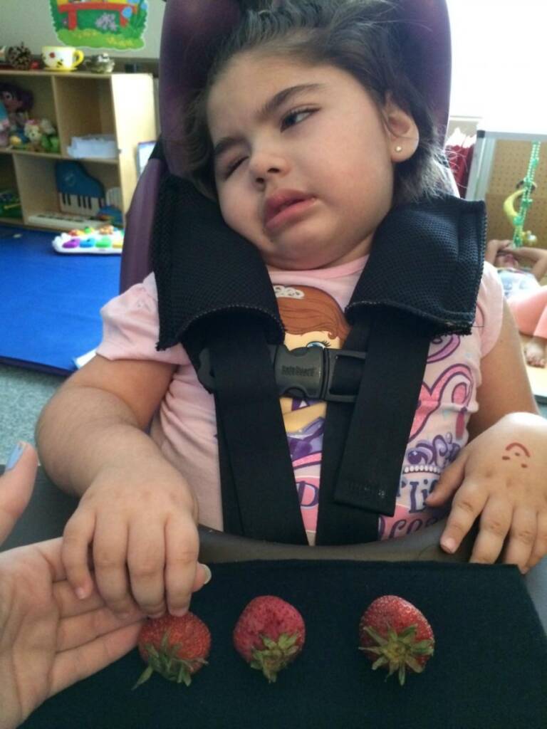 A girl explores strawberries