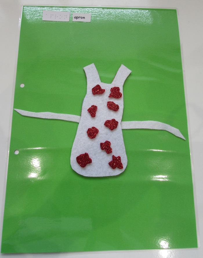tactile red dotted apron on green paper