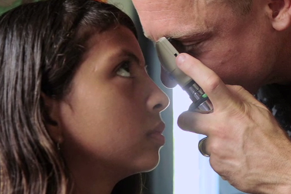 An ophthalmologist examines a girl's eyes