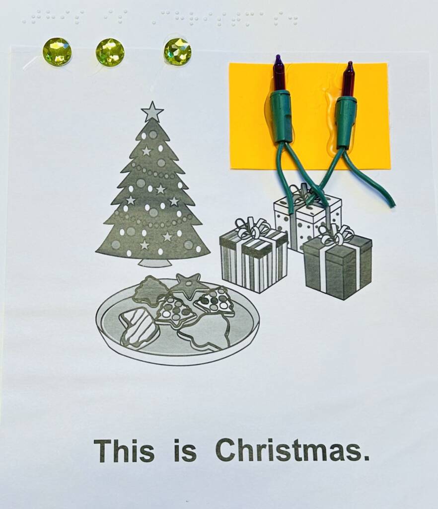 Braille and print page that says, "This is Christmas." with a photo of a tree, presents, and cookies. Two real Cghts attached.