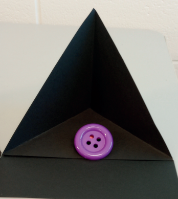 Black easel construction highlighting a large, purple button.