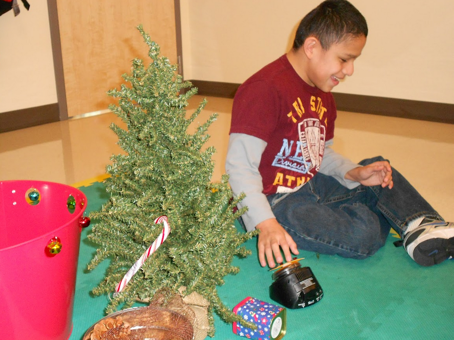Student enjoying holiday objects on the floor.