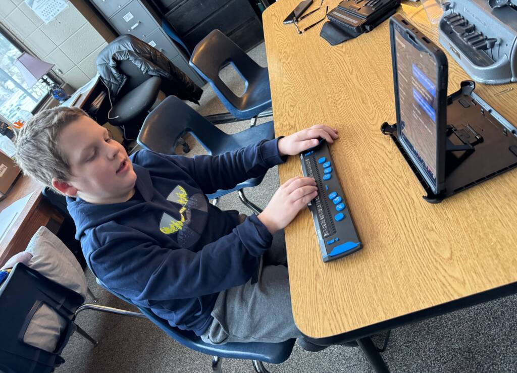 Liam using refreshable braille. 