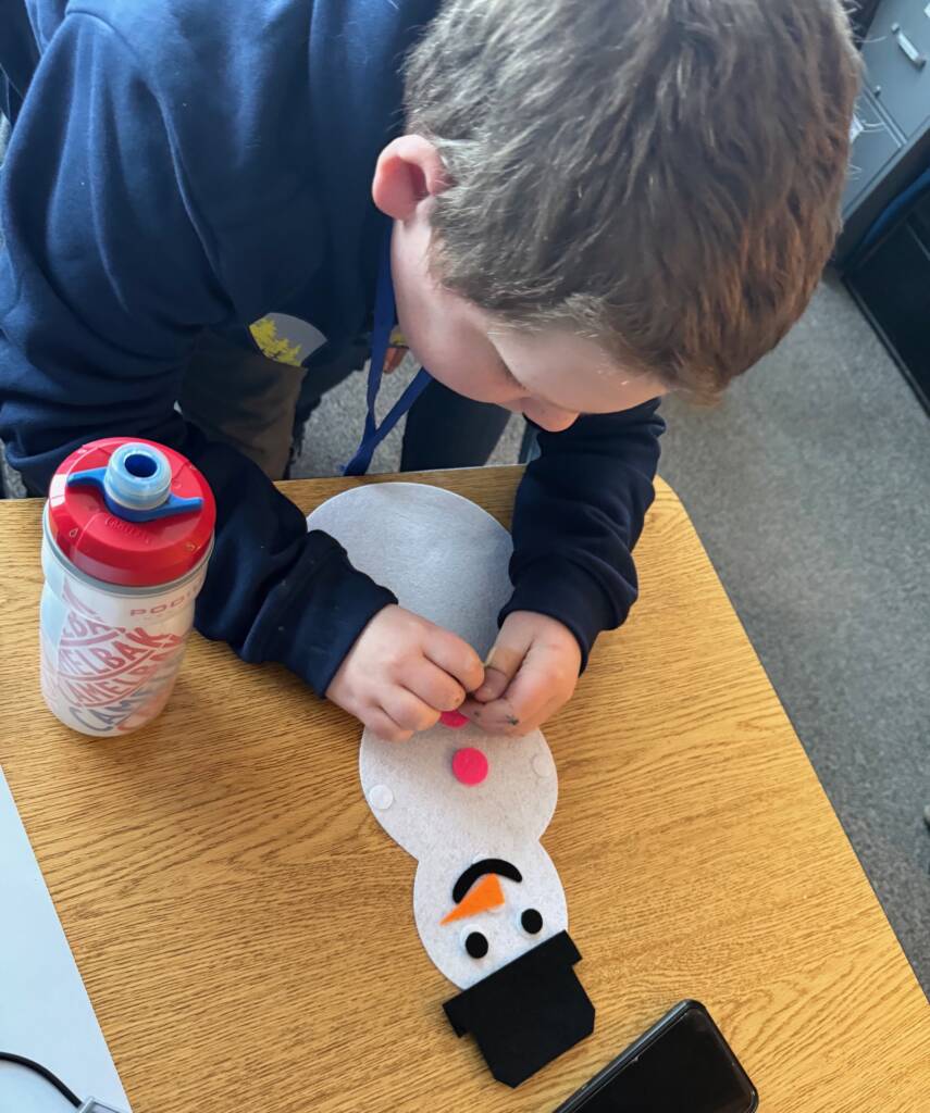 Liam putting the craft snowman together