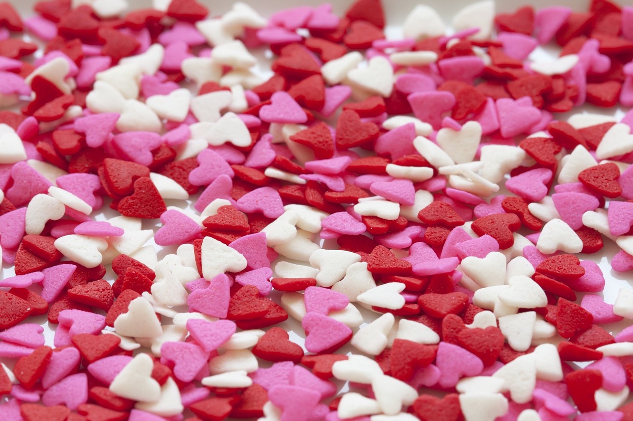 A pile of red, white, and pink heart shaped sprinkles