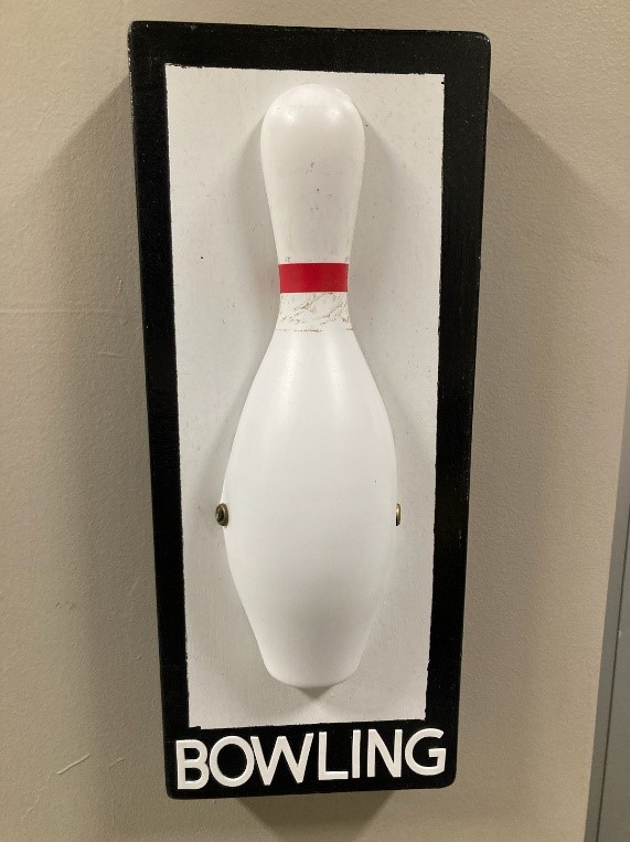 A bowling pin attached to a sign that says "bowling"