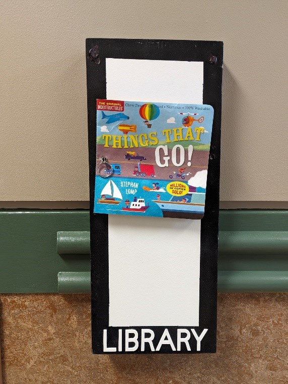 A sign reading "library" that has the book "things that go" attached to it