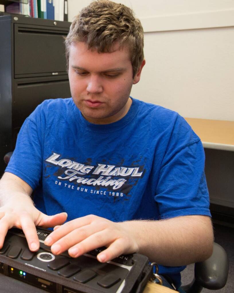 A teenager using a braille note taker