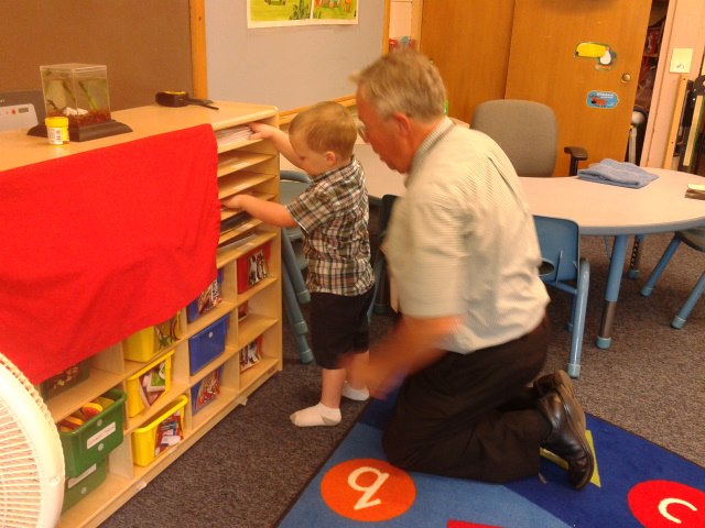 Liam exploring shelves in the classroom