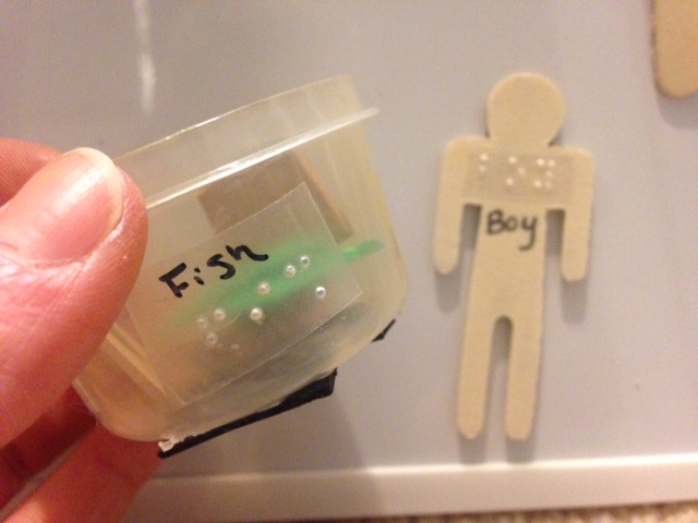 Small plastic container with braille label "fish"