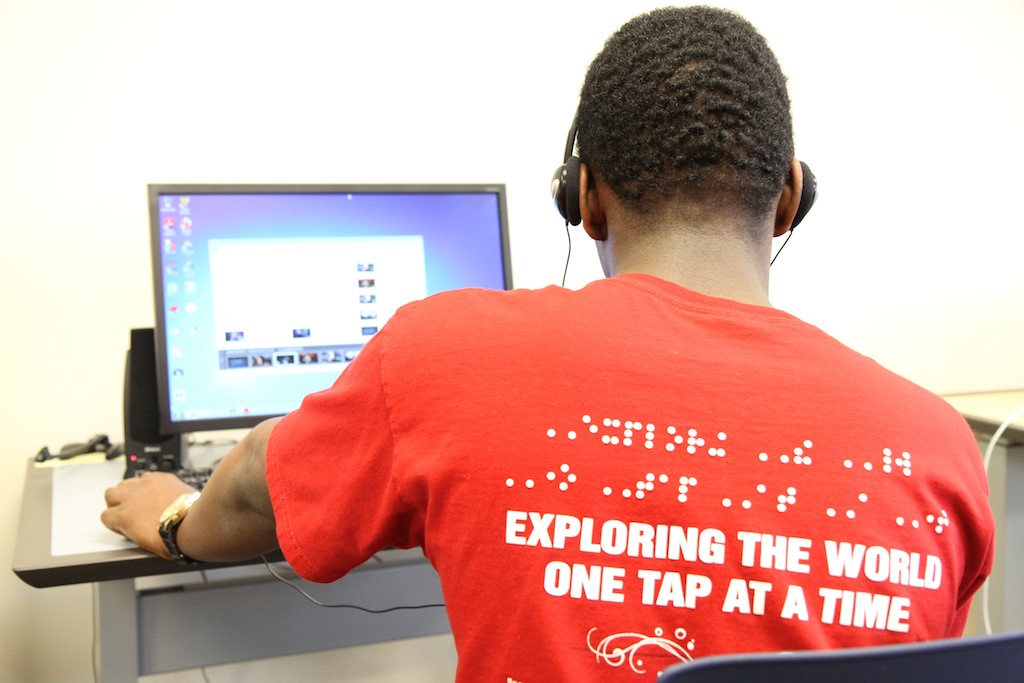 Student with headphones at a desktop computer