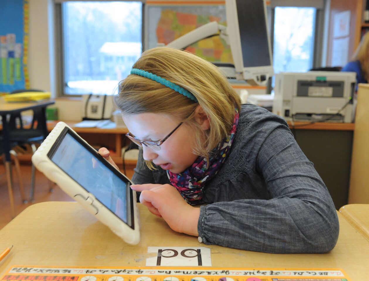 A girl with low vision examines an iPad at close range