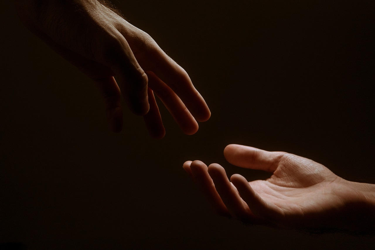 Two hands reaching towards each other