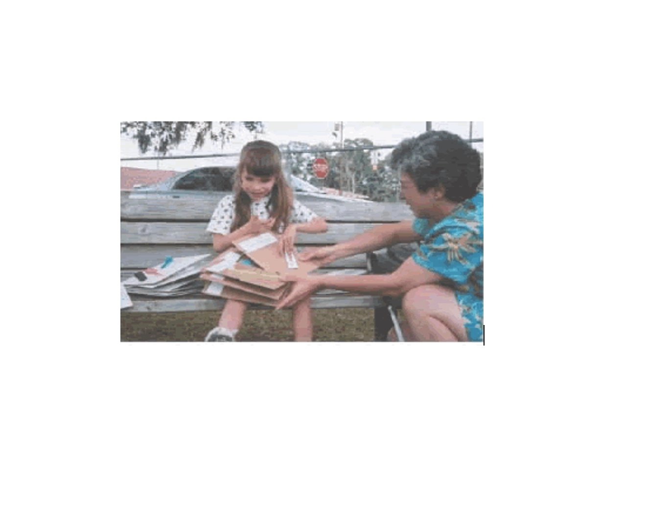 A young girl examines tactile books with her teacher