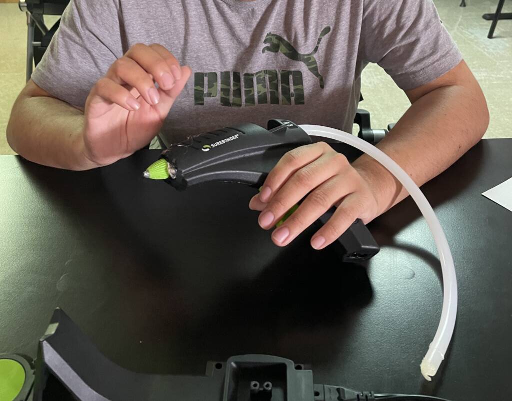 Student using a hot glue gun