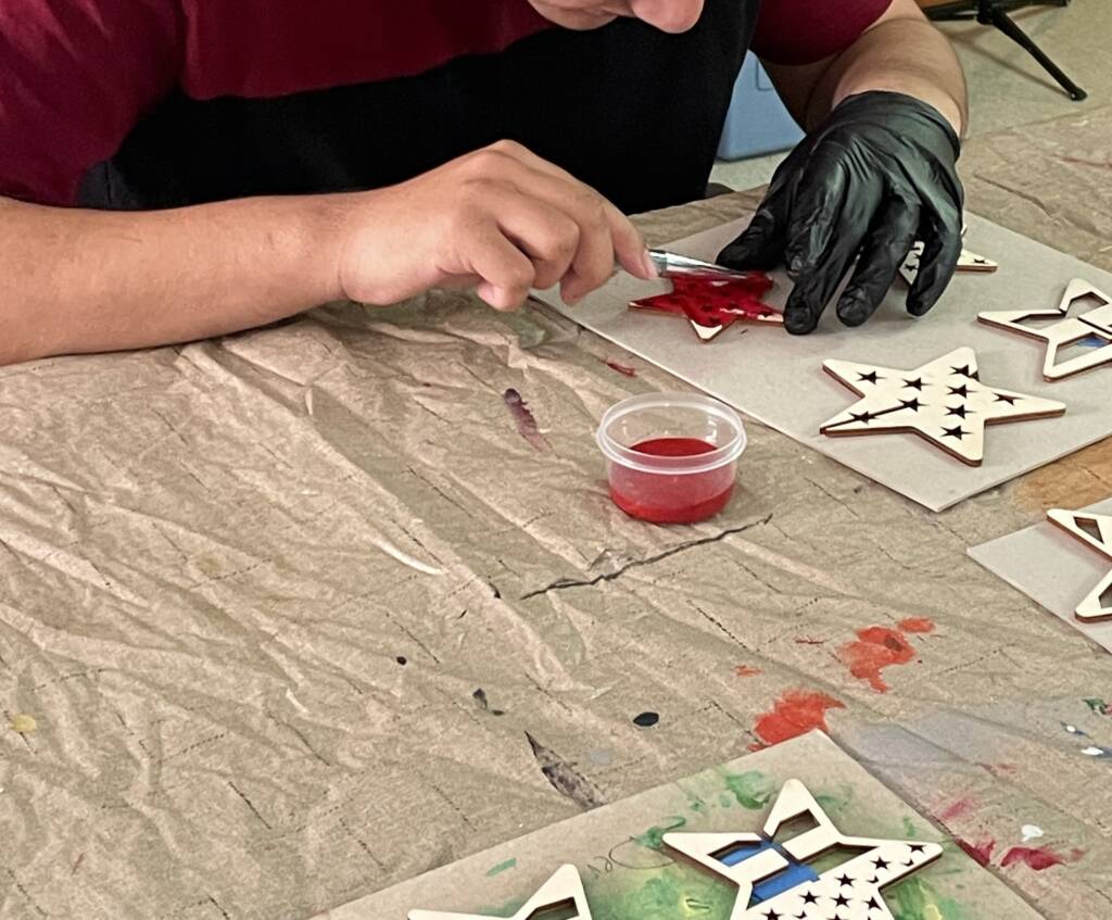 Student painting wooden stars