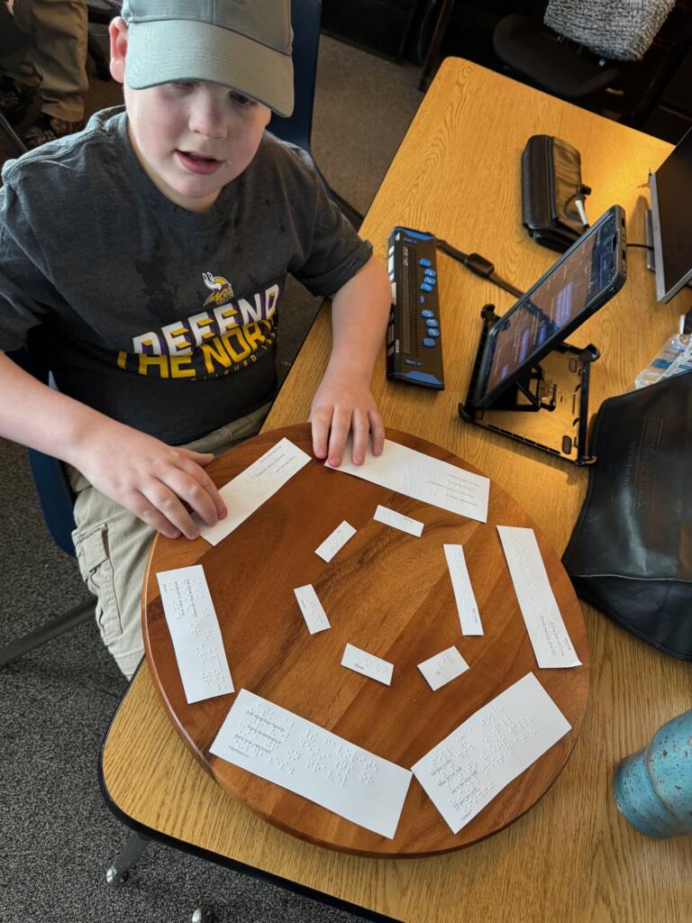 Liam reading his braille on the lazy Susan.