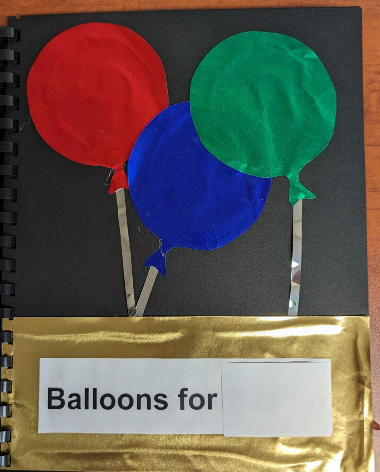 First page of the book with mylar balloons and the sentence, "Balloons for "name."