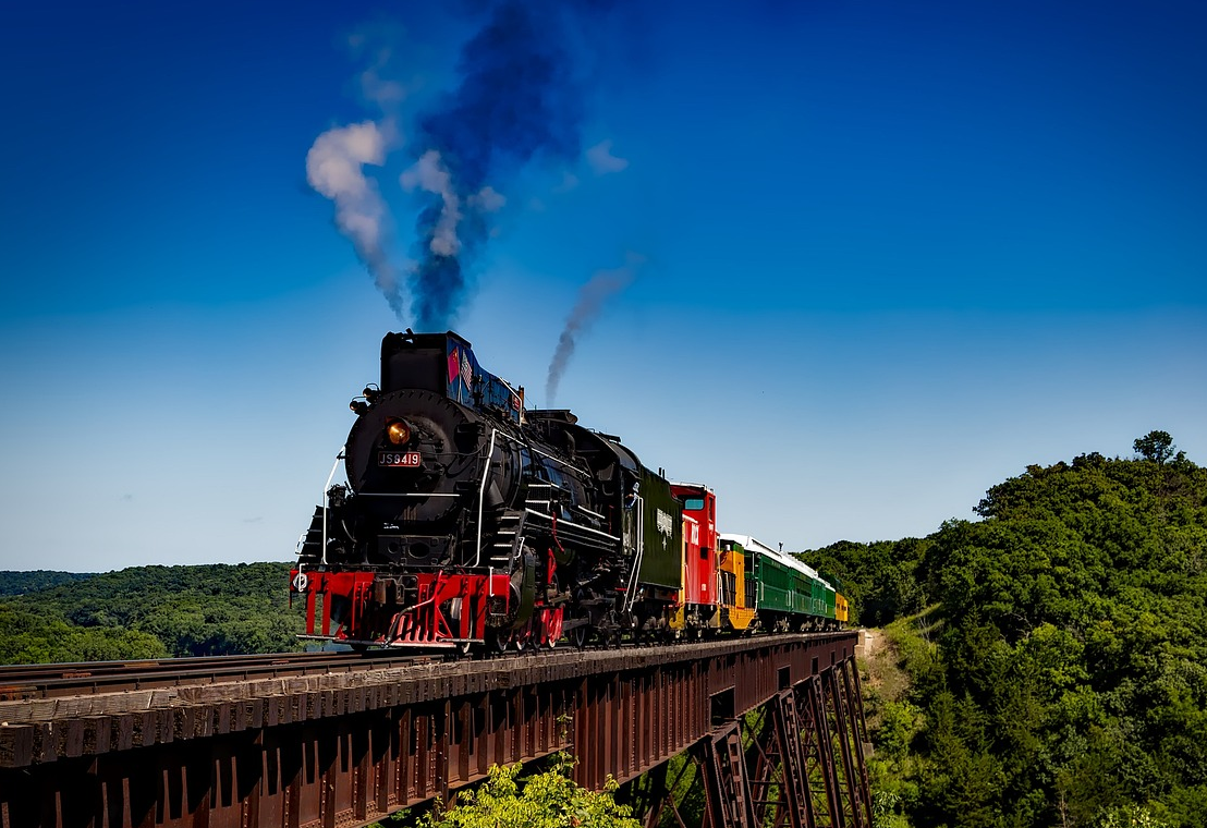 A train traveling along railroad tracks among trees