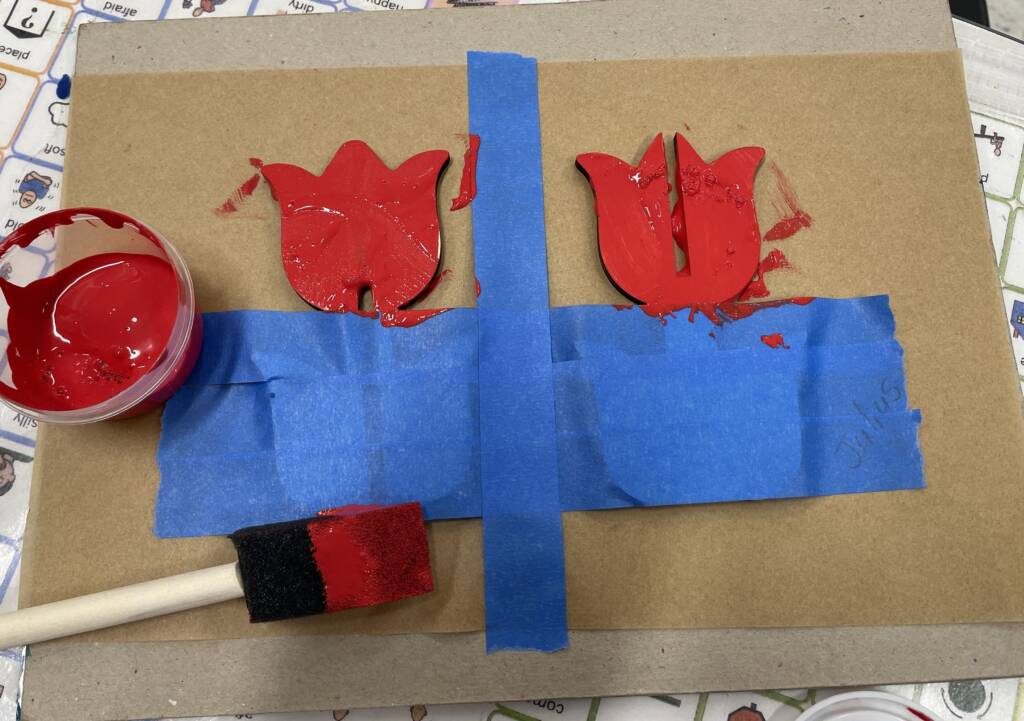 Painting the wooden tulips red.
