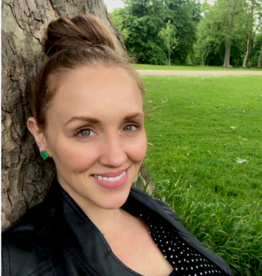 Rachel Waden smiling as she sits up against a tree.