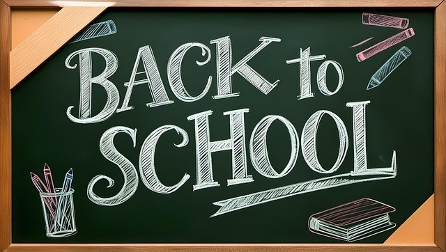 Back to school printed on a black board with crayons and book drawn around it. 