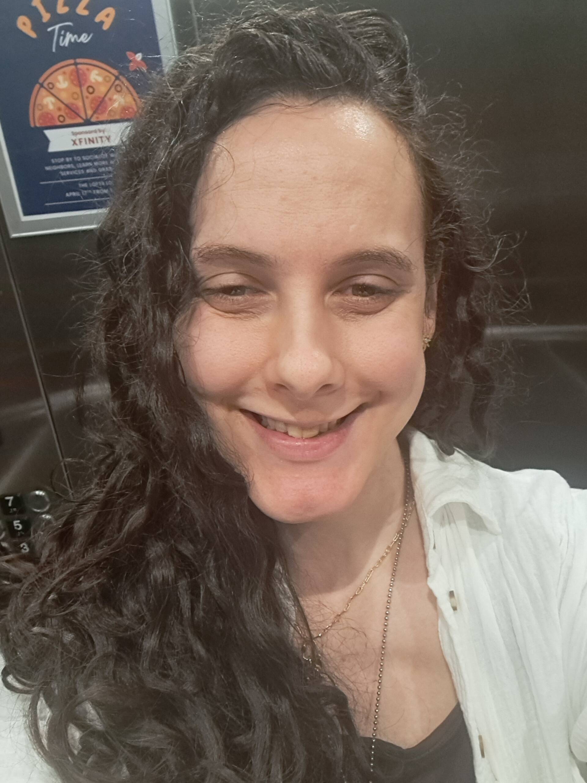 Blake Collins with a warm smile and long, wavy, brown hair.