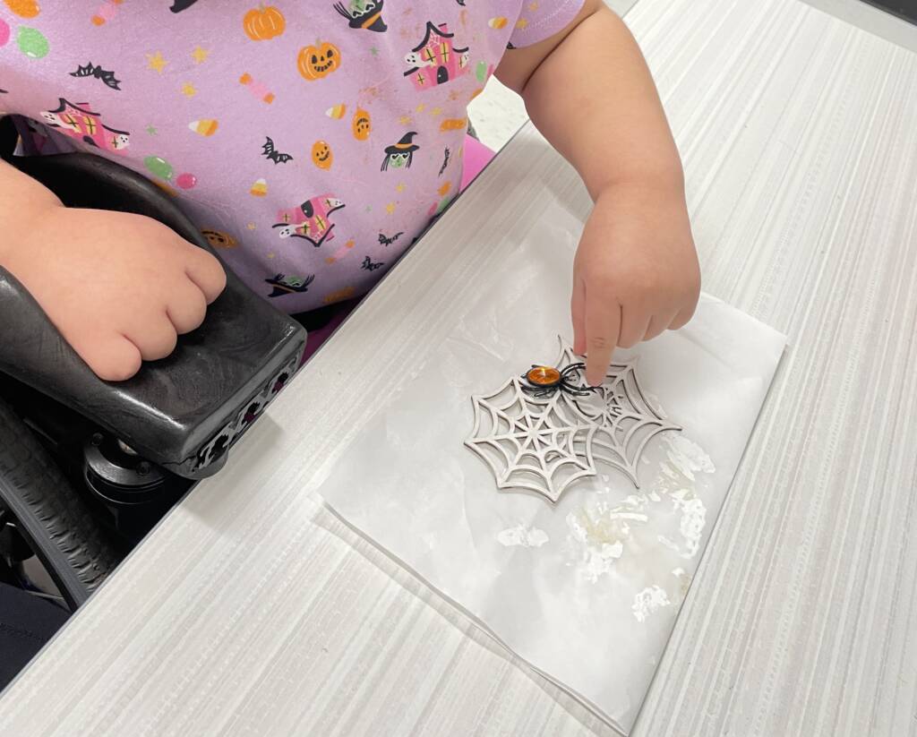 Student putting on a plastic spider.