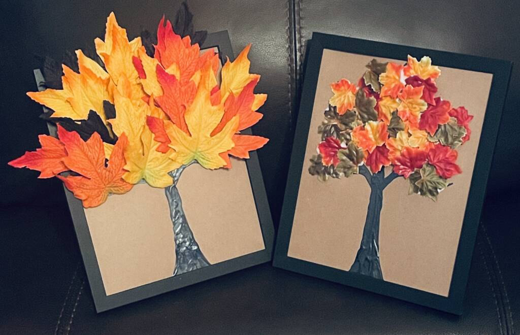 Two completed trees craft with plastic autumn leaves.